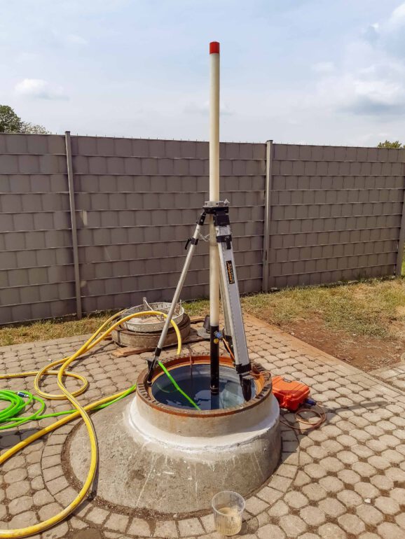 Dreibein auf wassergefülltem Betonschacht zur Dichtheitsprüfung