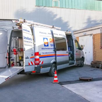 Mercedes Sprinter mit geöffneten Hecktüren und geöffneter Seitentür der OKO-tech Umweltservice GmbH und Dreibein auf einem Schacht