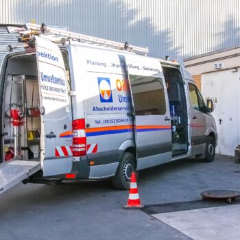Mercedes Sprinter mit geöffneten Hecktüren und geöffneter Seitentür der OKO-tech Umweltservice GmbH und Dreibein auf einem Schacht