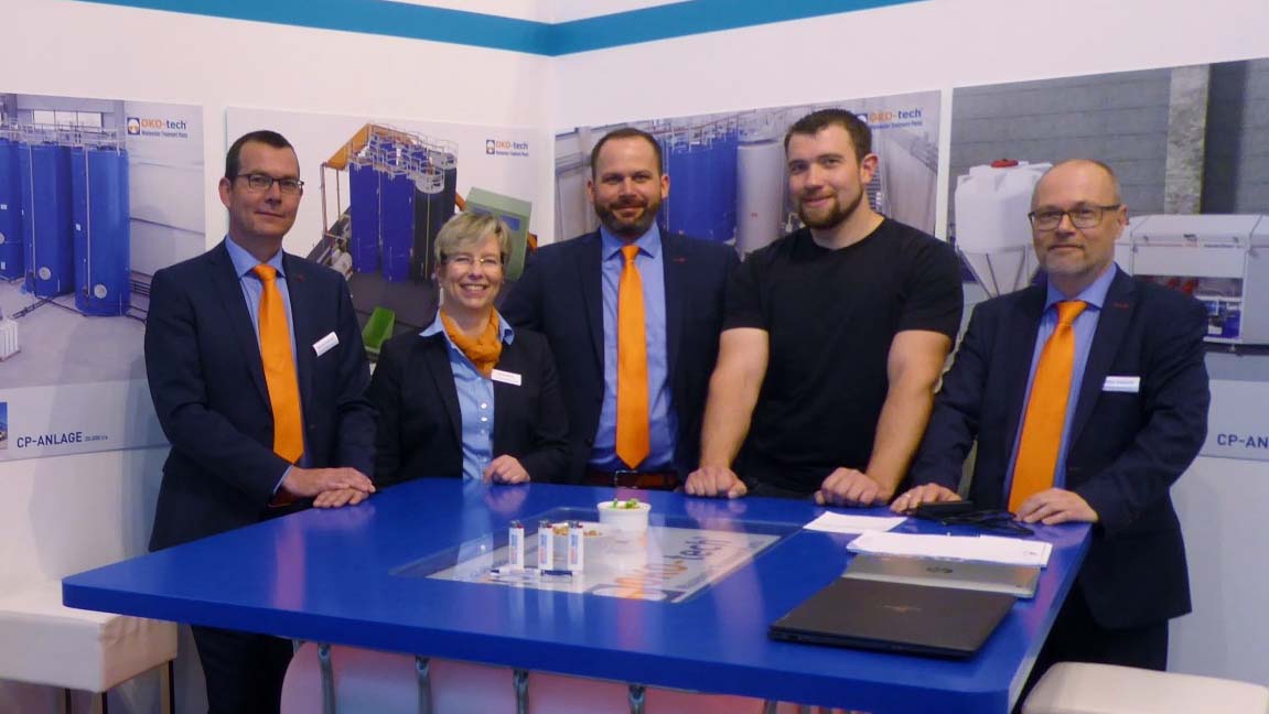 Fünf Mitarbeiter auf einem Messestand der OKO-tech GmbH & Co. KG